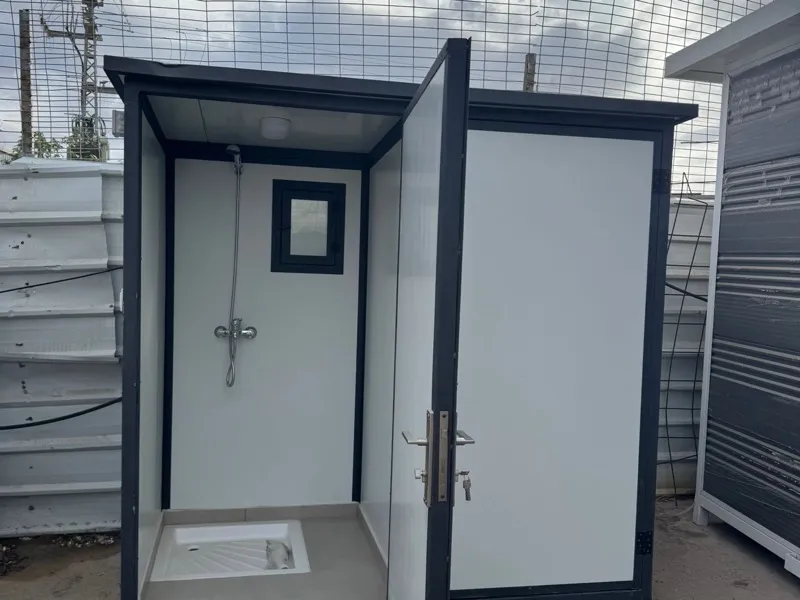 תא שירותים ומקלחת נייד עם דלת פתוחה